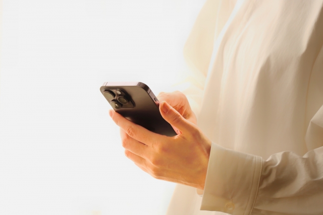 肩こりになる原因のスマホの見過ぎを行っている女性